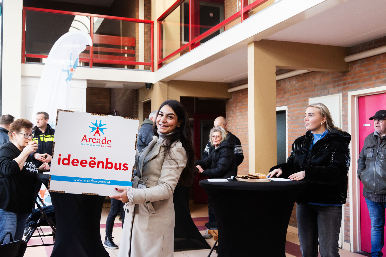 In de ideeënbus die Maya Manok (sociaal beheerder bij Arcade) vasthoudt, konden bewoners hun ideeën delen voor de binnentuin en activiteiten ter bevordering van de leefbaarheid.