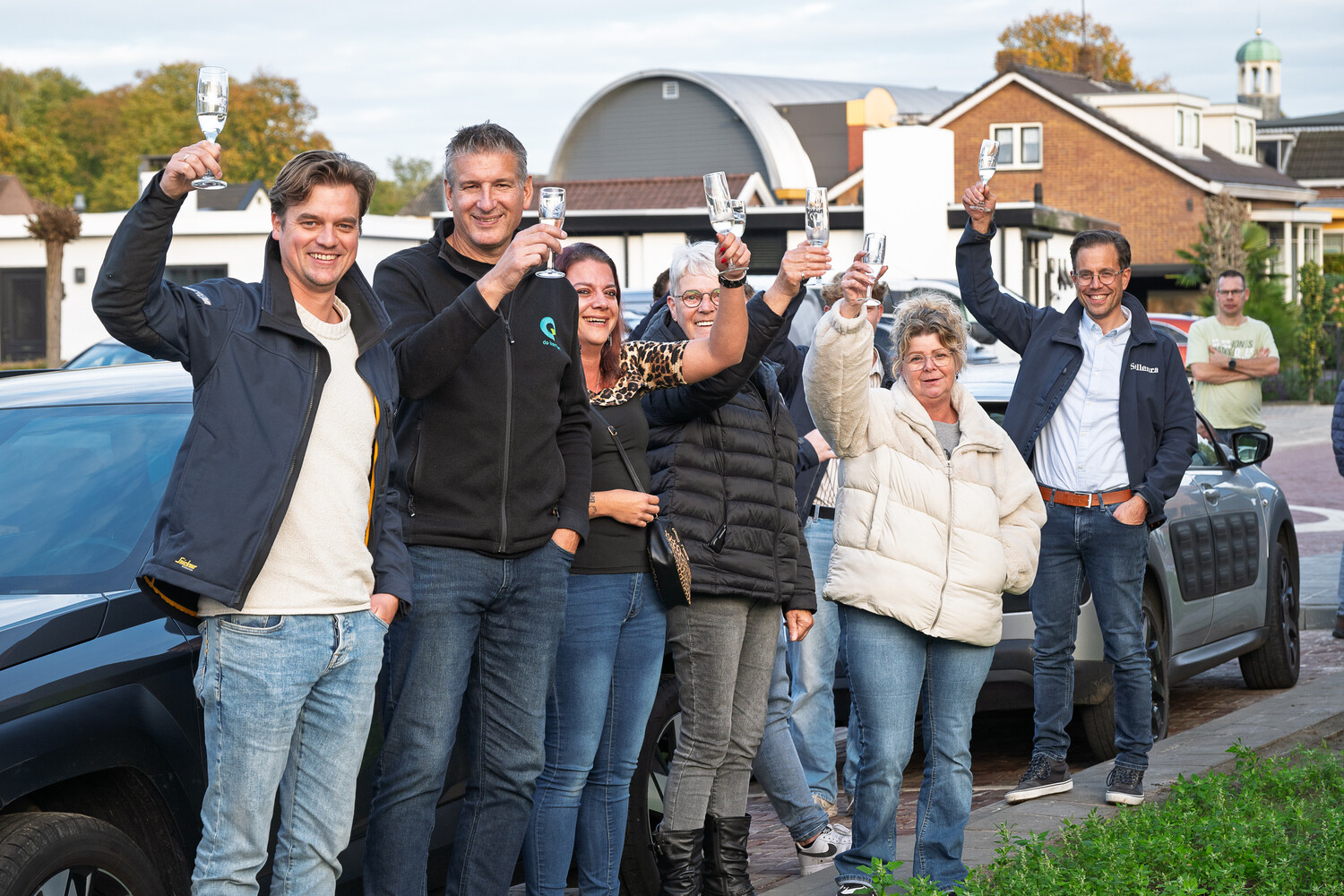 Aanwezigen heffen het glas voor een toost.