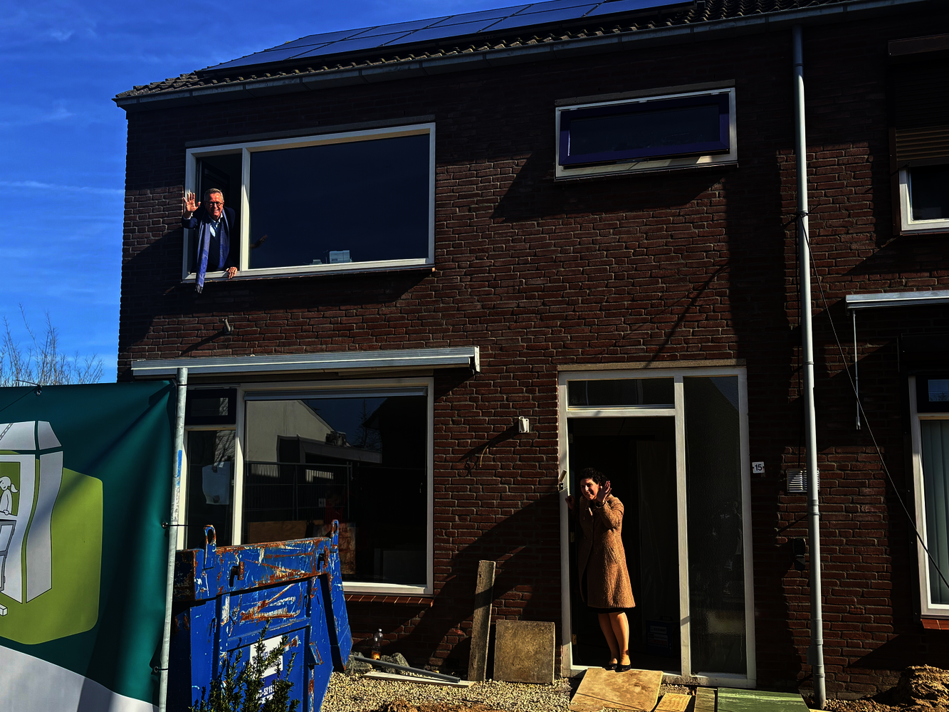 Marinus Kempe (Directeur-bestuurder Woonstichting De Kernen) en Wethouder Marieke van den Boom (gemeente West Maas en Waal) staan samen op de foto voor de woning die wordt gesplitst.