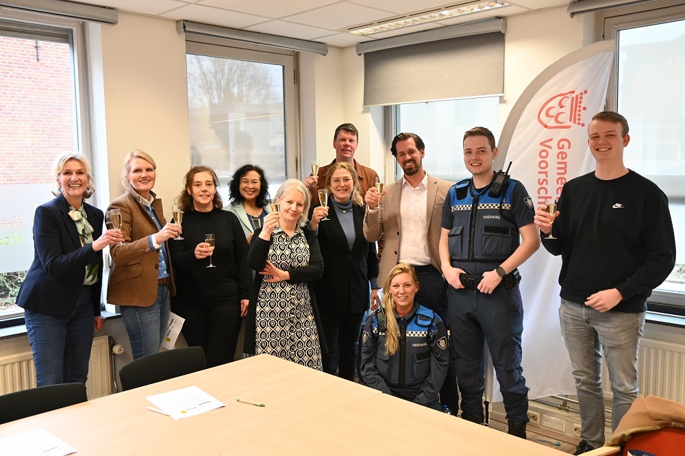 Groep mensen die proosten op samenwerking buurtbemiddeling