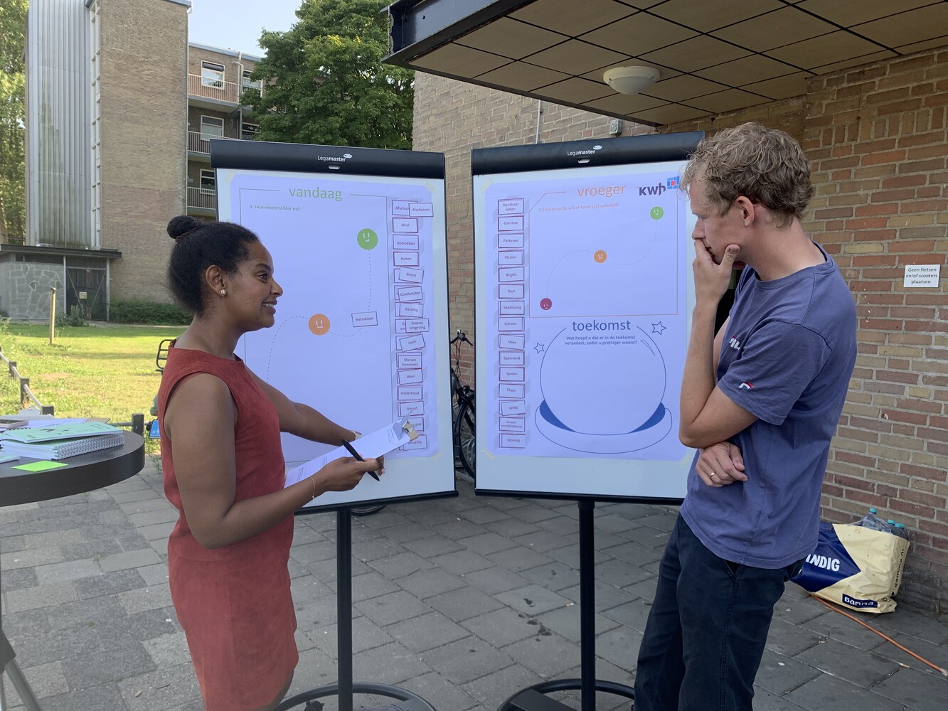 Twee personen bij een bord tijdens de flatbijeenkomst