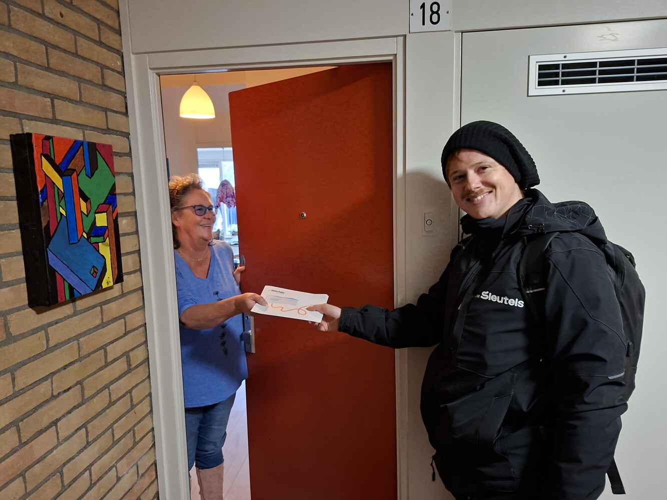 Wijkbeheerder Daan van De Sleutels bedankt huurder voor het meedoen aan het reputatie-onderzoek. De huurder ontvangt haar cadeaubon.