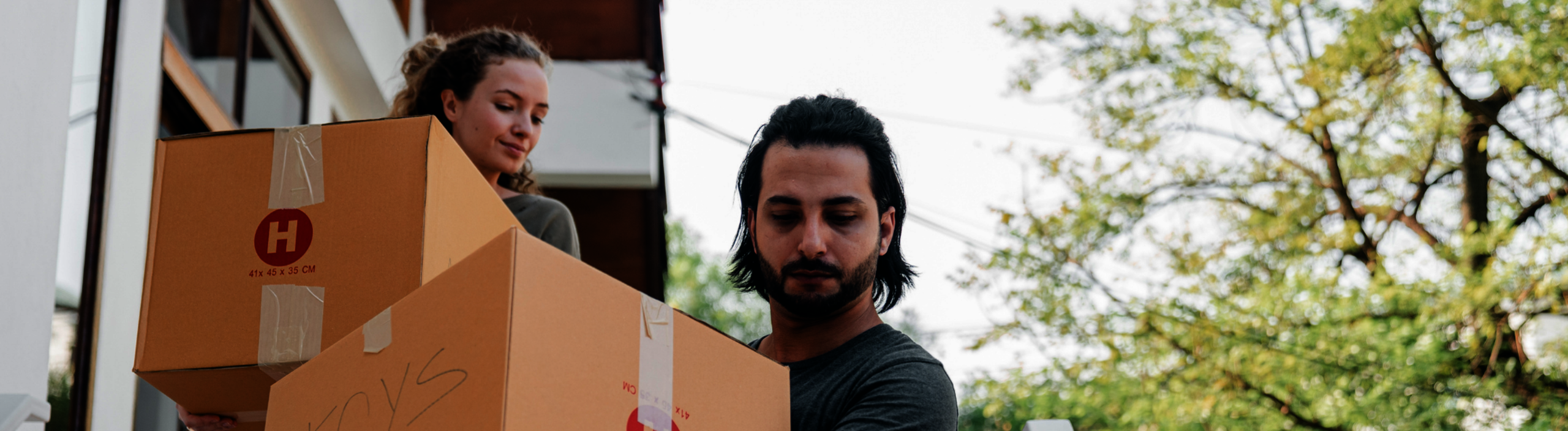 Banner: man en vrouw verhuizen en tillen dozen