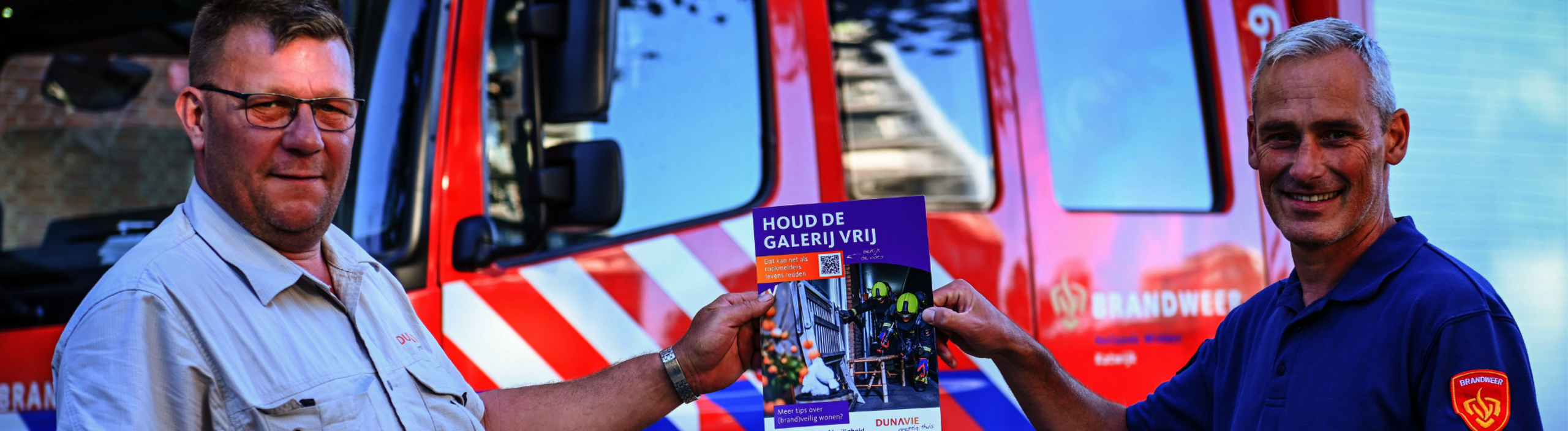 Banner: werknemer van dunavie en brandweerman voor een brandweerauto