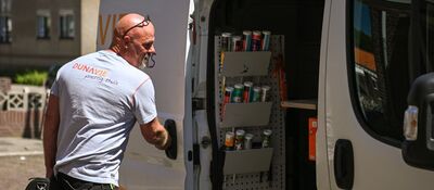 Banner: vakman van Dunavie staat bij een werkbus