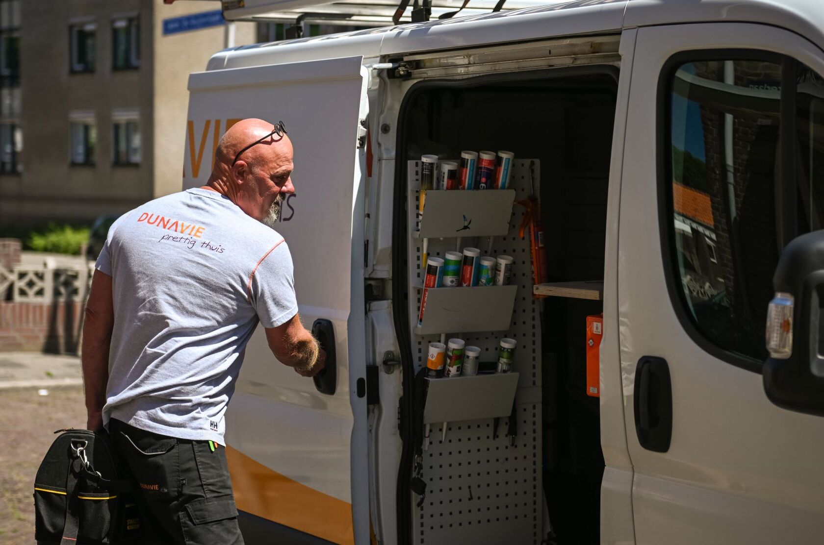 Banner: vakman van Dunavie staat bij een werkbus