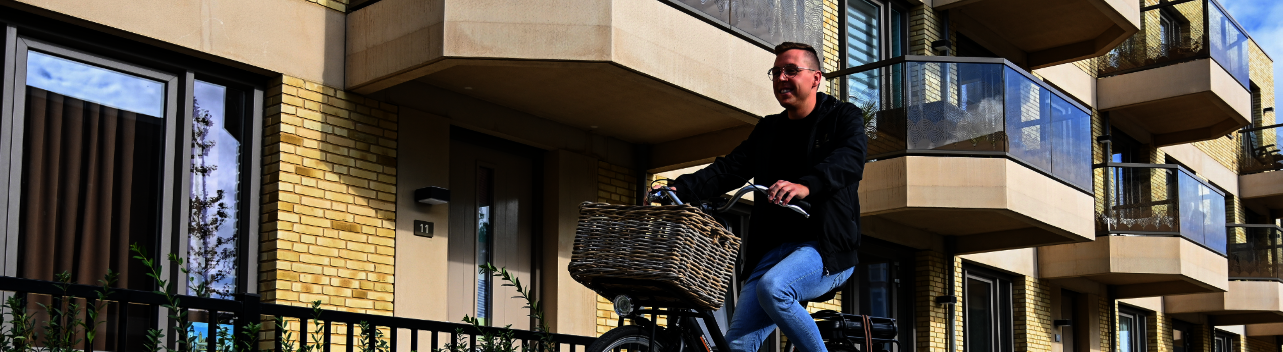 Banner huurder fietst langs pand van Dunavie