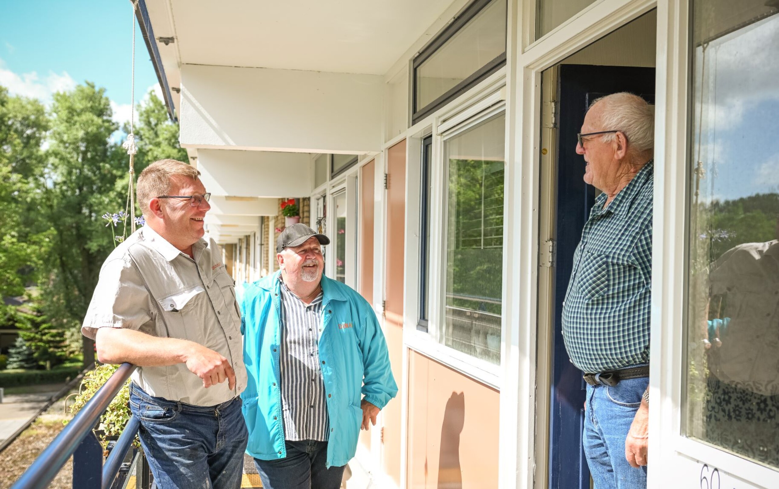Banner: collega's Dunavie staan aan de deur met een huurder te praten