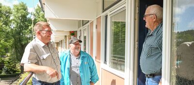 Banner: collega's Dunavie staan aan de deur met een huurder te praten