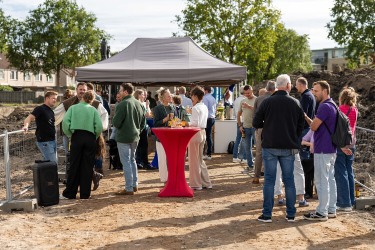 Bezoekers praten met elkaar op een bouwlocatie