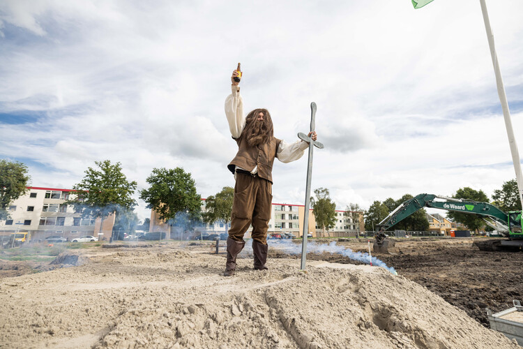 Persoon met groot zwaard staat op een bouwterrein