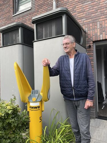 Frans Kreté voor de systeemkast met warmtepomp bij zijn woning