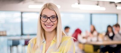 Jonge medewerker met op achtergrond collega's - vacatures en stage Goed Wonen Gemert