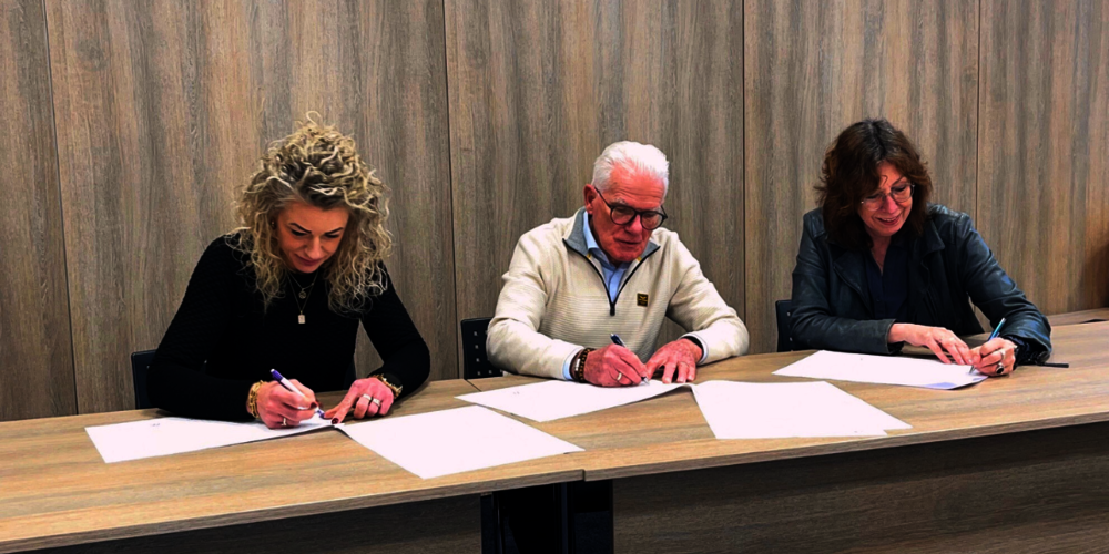 Foto van de drie partijen die hun handtekening zetten.