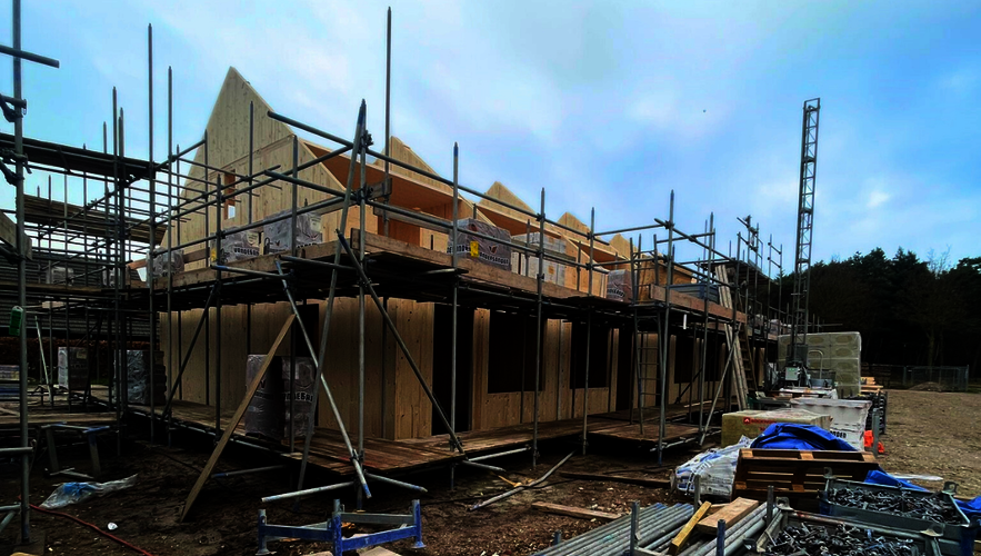 Foto van het begin van de bouw waarop je goed het houtskelet ziet.