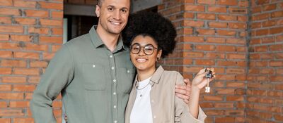 Jong stel met sleutel van hun nieuwe woning