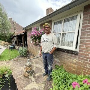Frits de Sadeleer staand in de achtertuin van zijn woning