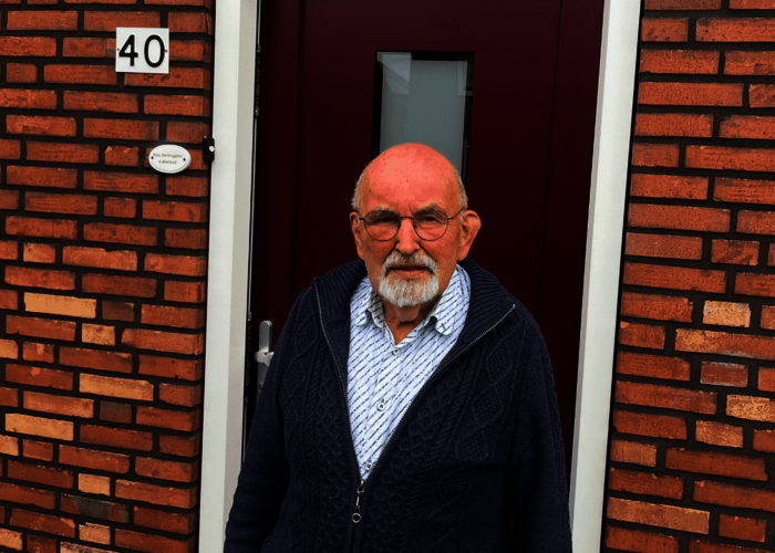 Toon Verbruggen staand voor de voordeur van zijn woning