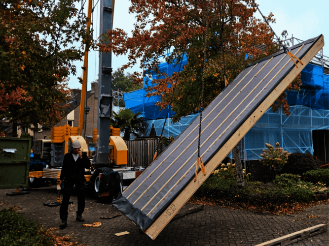 Een biobased dakplaat hangt half van de grond in de kettingen.