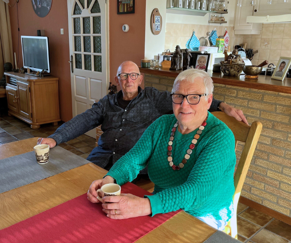 De heer en mevrouw Van den Berg aan hun eetkamertafel met een kopje koffie in de hand