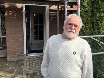 Arno de wit voor zijn woning die wordt gerenoveerd