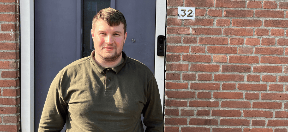 Dyllan van Dalen voor de voordeur van zijn woning (foto vanaf borsthoogte)