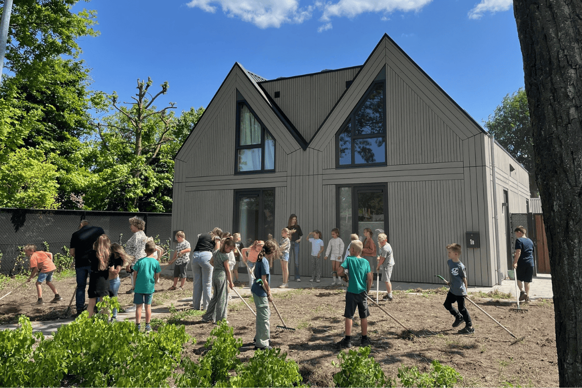 Twee woningen aan de Abtshof waar leerlingen aan het werk zijn in de voortuin