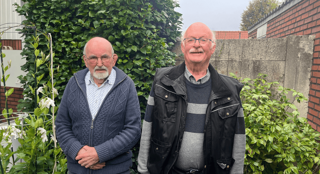 Toon en Arie staan naast elkaar in de achtertuin