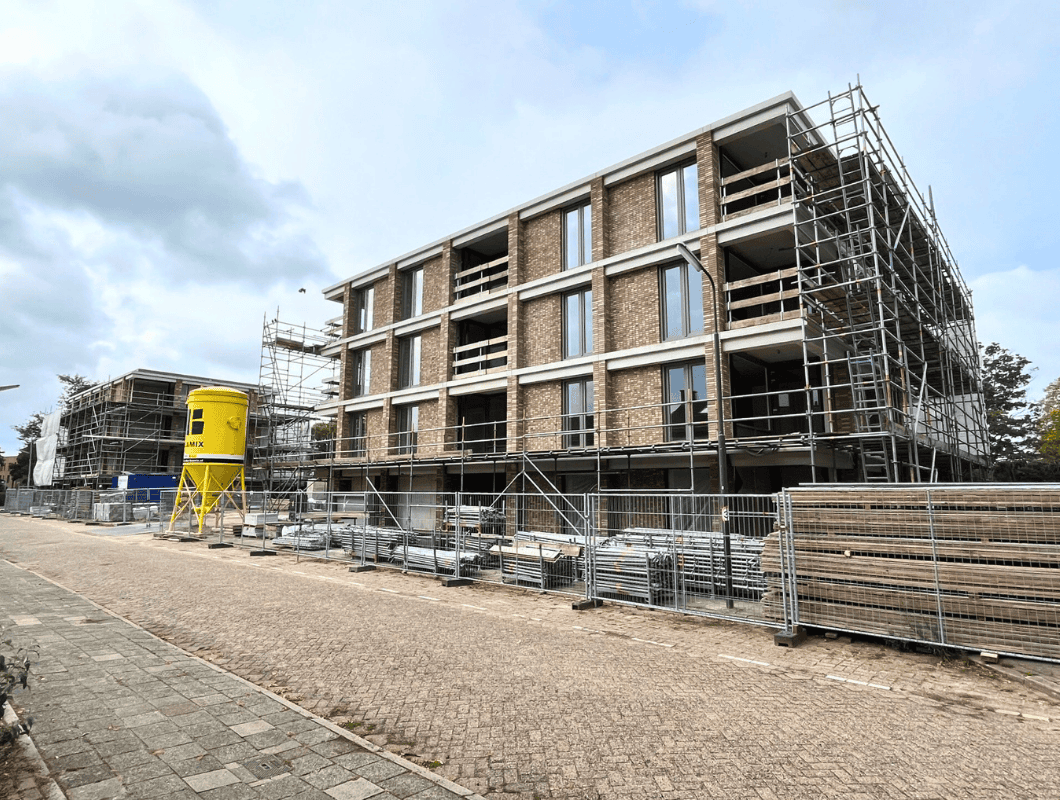 Foto van de 2 appartementencomplexen in aanbouw met 1 groot op de voorgrond het het tweede klein op de achtergrond in de verte