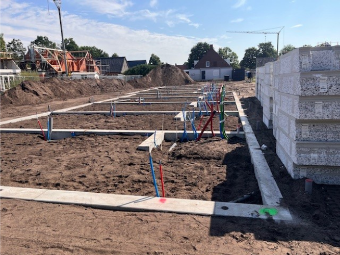 Grond met daarin met beton de buitenste randen van de woningen zichtbaar