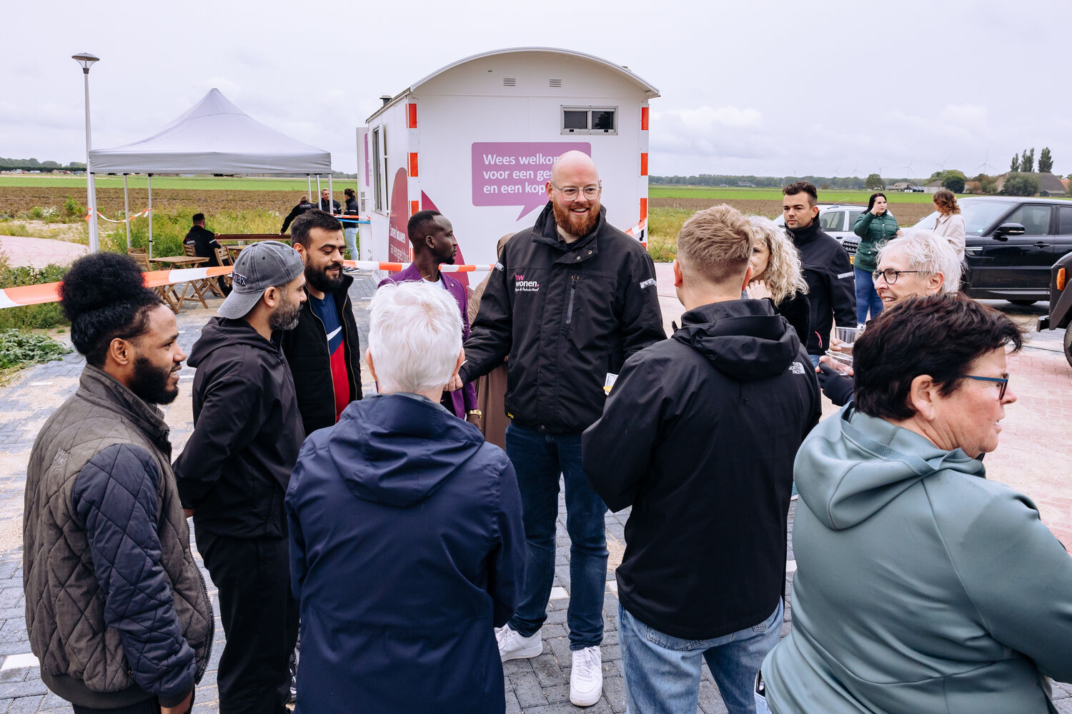 Consulent Sociaal Beheer Wesley Rotteveel deelt patat uit aan een groepje bewoners en omwonenden van de Nautalaan.