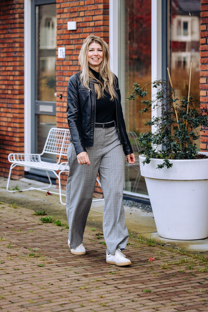 Bianca loopt over straat langs een rij huizen
