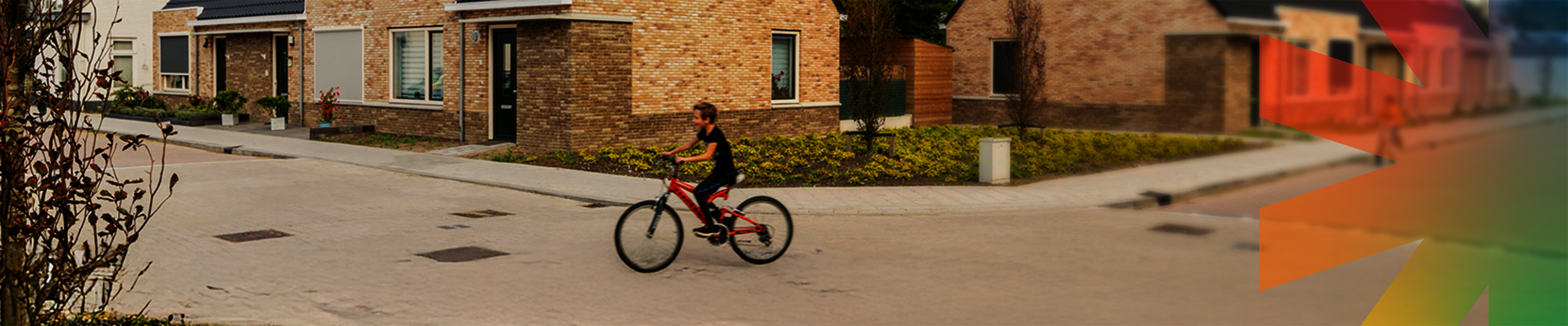 Een jongen fietst op straat voor nieuwe woningen 