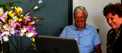 Een ouder echtpaar zit achter een laptop