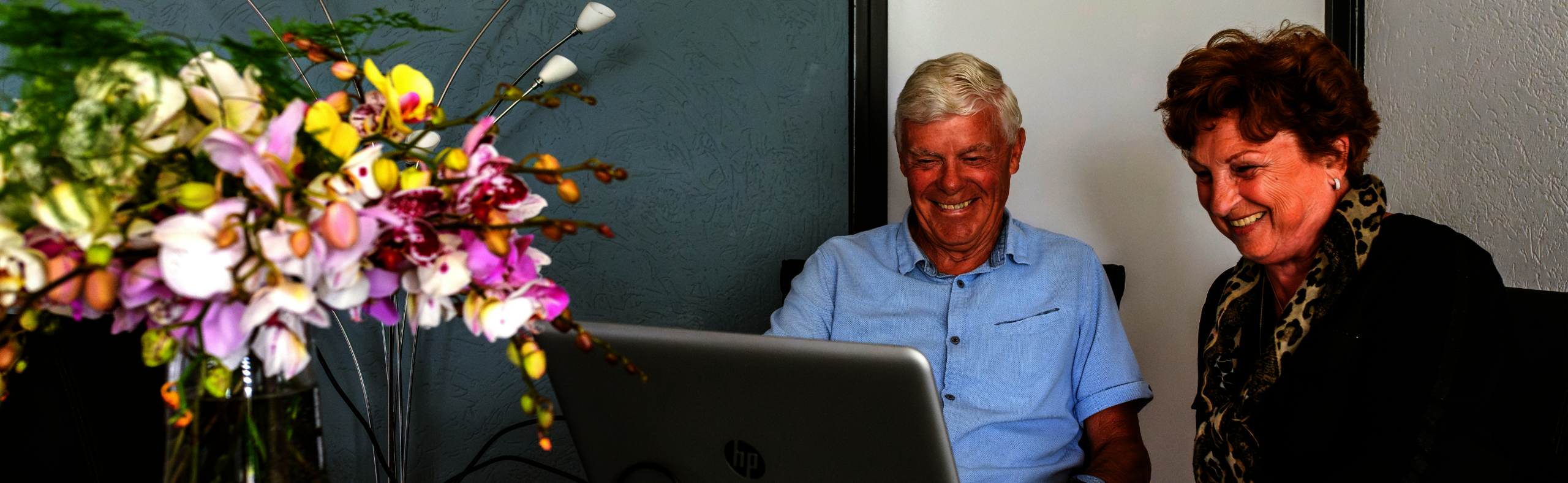 Een ouder echtpaar zit achter een laptop