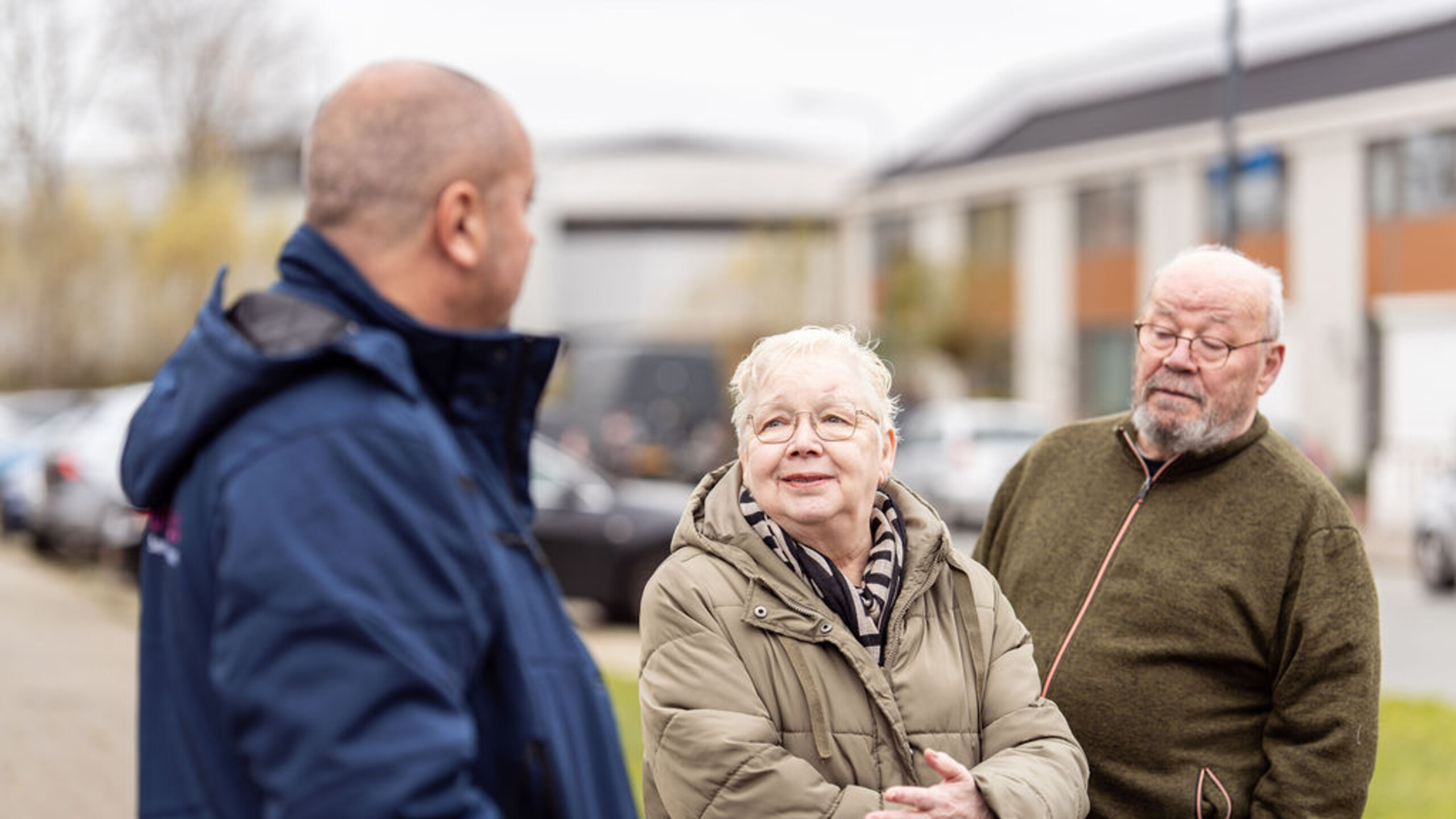 Drie oudere mensen met elkaar in gesprek op straat