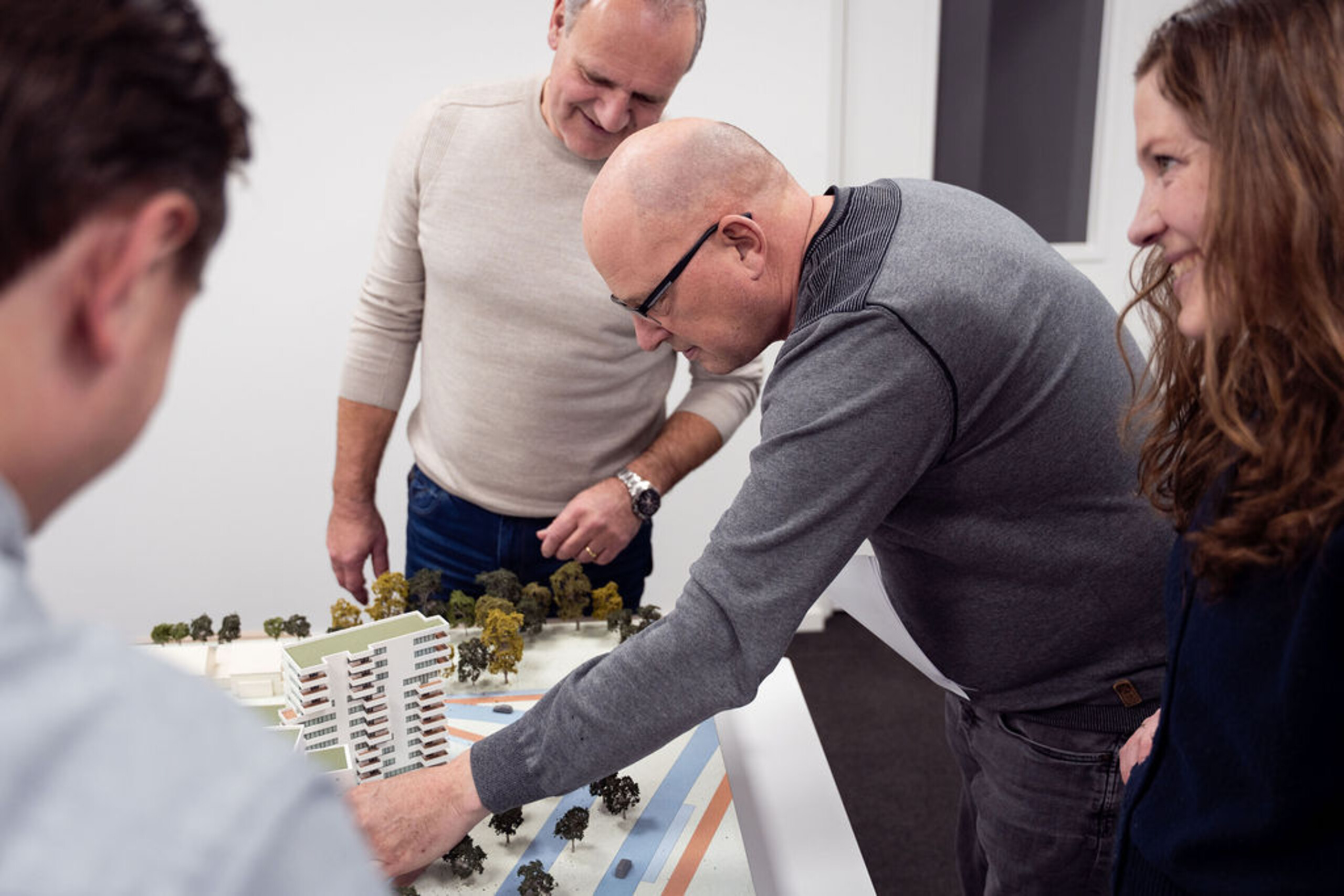 Groepje mensen bekijkt een maquette van een buurt