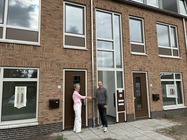 bewoner ontvangt sleutel van woning Mooiland
