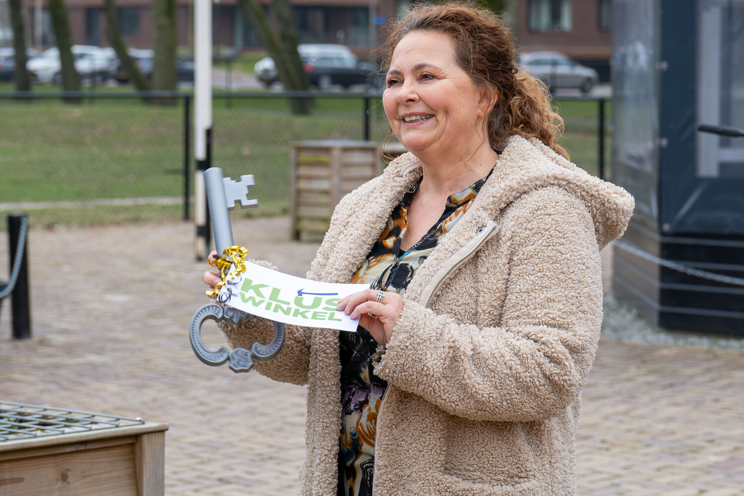 Manager Klant OFW, Nathalie Crone, overhandigt symbolisch een sleutel voor de nieuwe opslagruimte voor spullen van de Kluswinkel