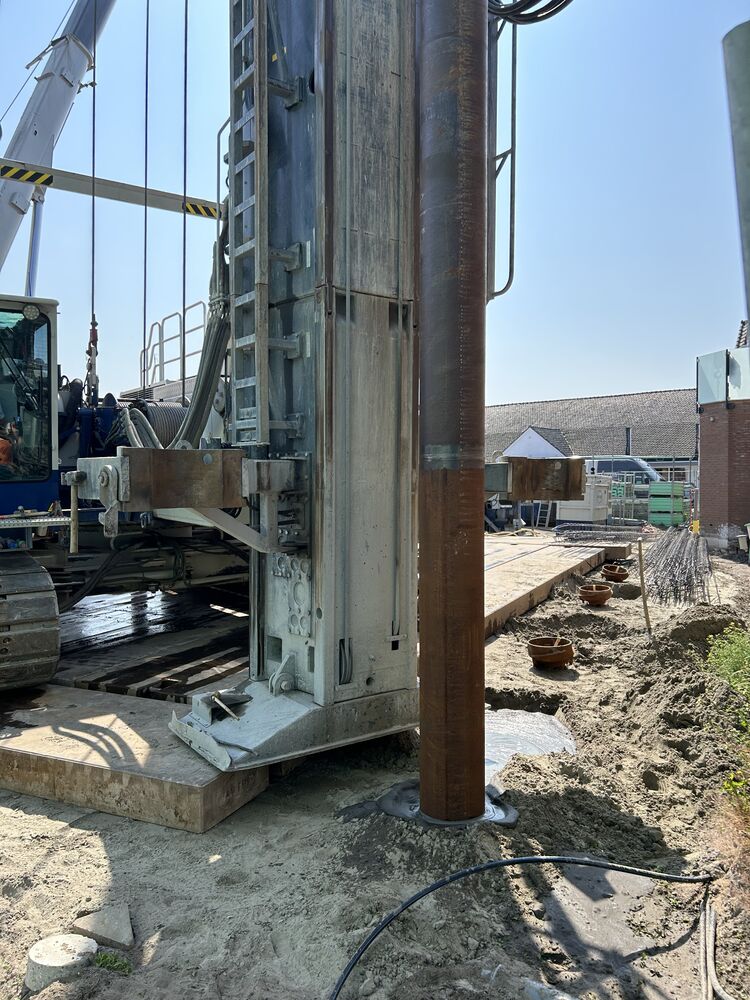 Een beeld van een heipaal die de grond in gaat bij nieuwbouwproject Nelisse in Ouddorp.