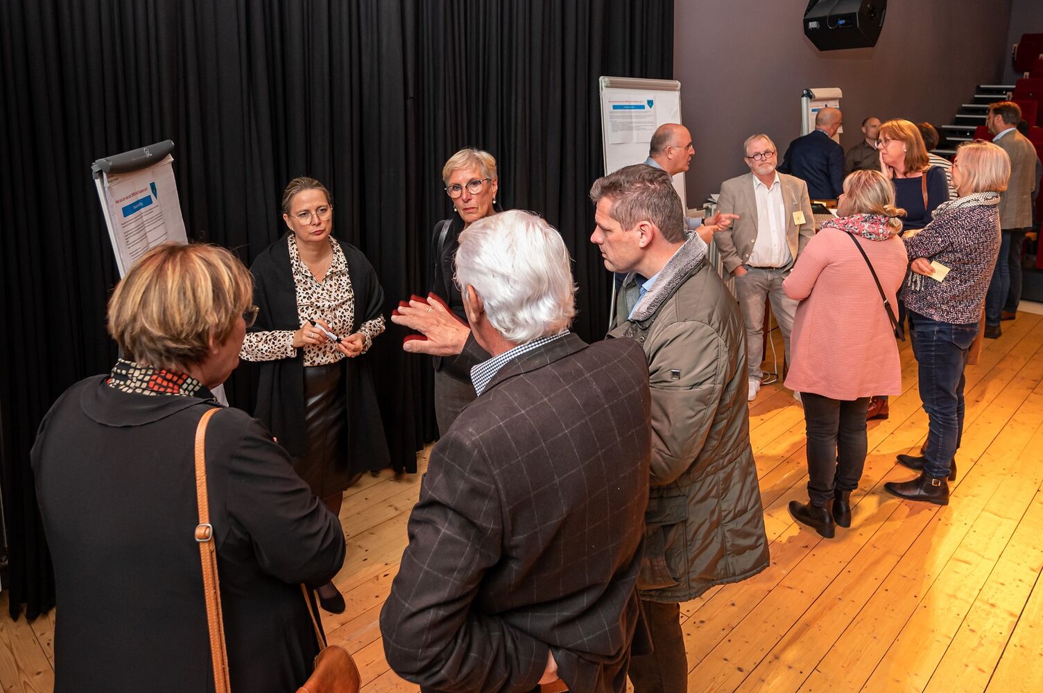Op het beeld zijn collega's van Oost West Wonen en stakeholders in gesprek bij flip-overs te zien.