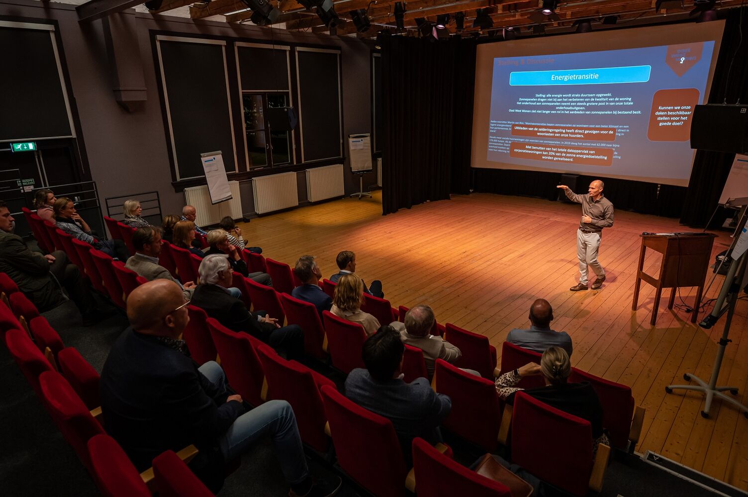 Op het beeld is te zien hoe een collega van Oost West Wonen een presentatie in zaal geeft.