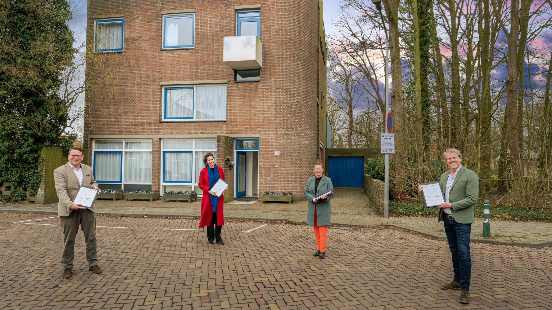 Op het beeld zijn bestuurder Aimee Heijdenrijk van zorgorganisatie Pameijer, directeur-bestuurder Marleen van de Kamp van woningcorporatie Oost West Wonen, wethouder Léon Soeterboek van de gemeente Nissewaard en wethouder Berend Jan Bruggeman van de gemeente Goeree-Overflakkee te zien voor het complex aan de Hobbemastraat in Middelharnis. 