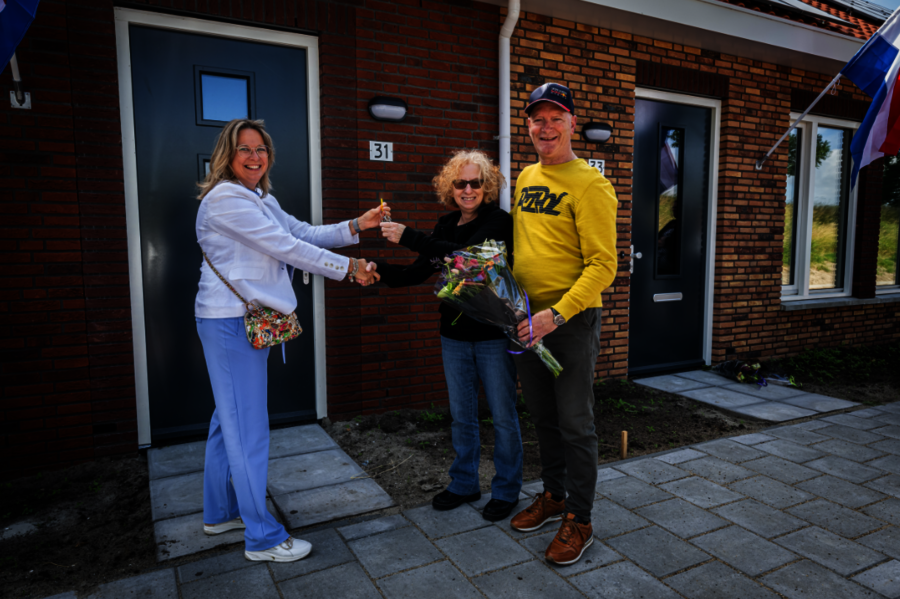 Een beeld van de huurders die de sleutel van hun nieuwe huurwoning in ontvangst nemen van Marleen van de Kamp, bestuurder van Oost West Wonen.