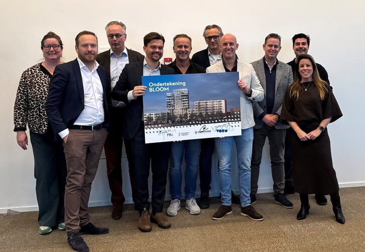 De mensen die het contract tekenden poseren