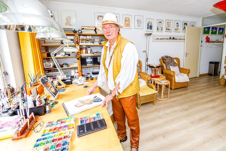 Rudy, portetschilder, staat bij zijn portretten