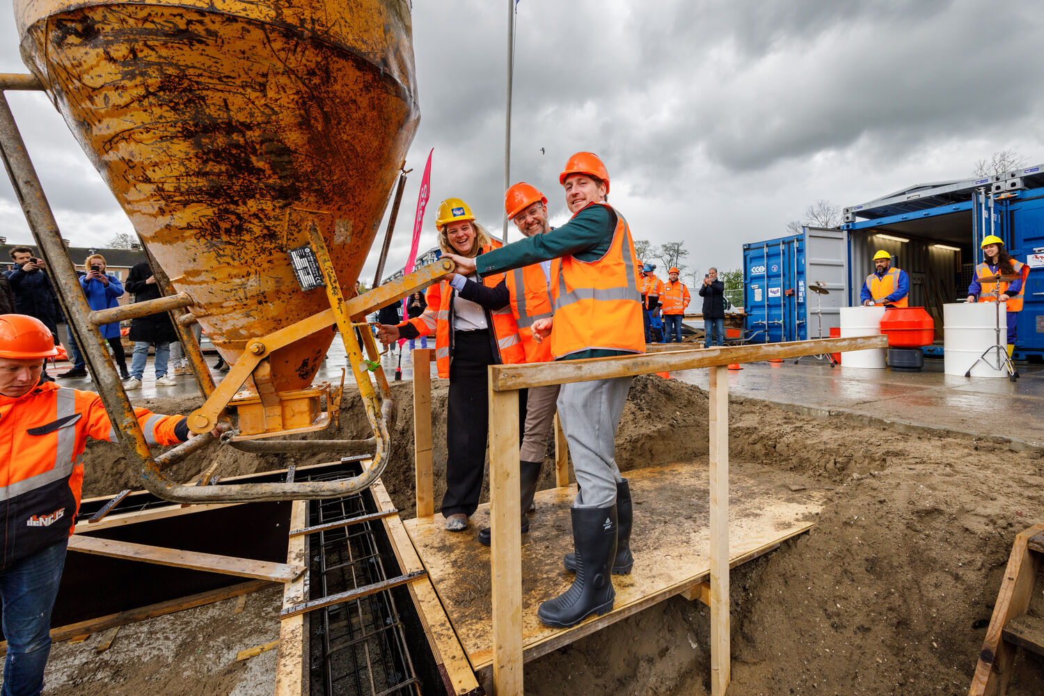 Foto: Onder de luide klanken van percussieband Drumboost, die op cementmolens en kruiwagens trommelden, stortten Reinier van Dantzig, Egbert Dekker en Daniëlle de Nijs beton in een funderingsbalk.