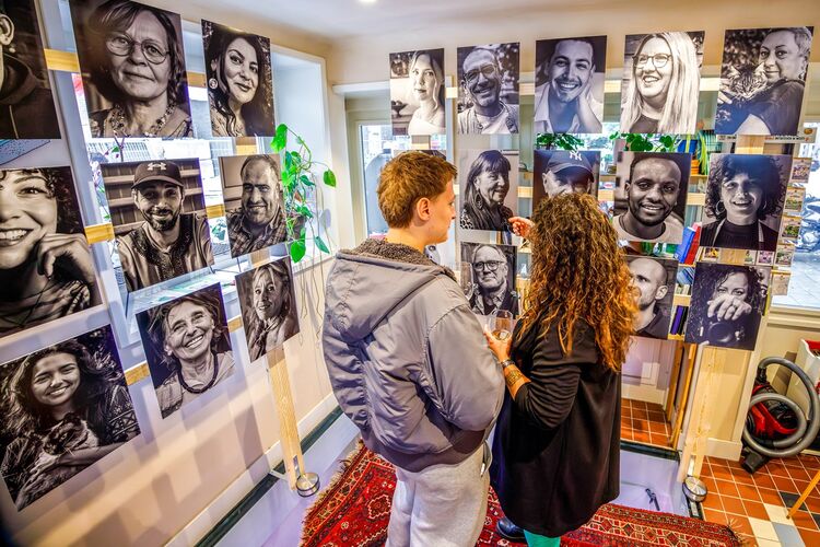 Bezoekers van de tentoonstelling kijken naar de foto's