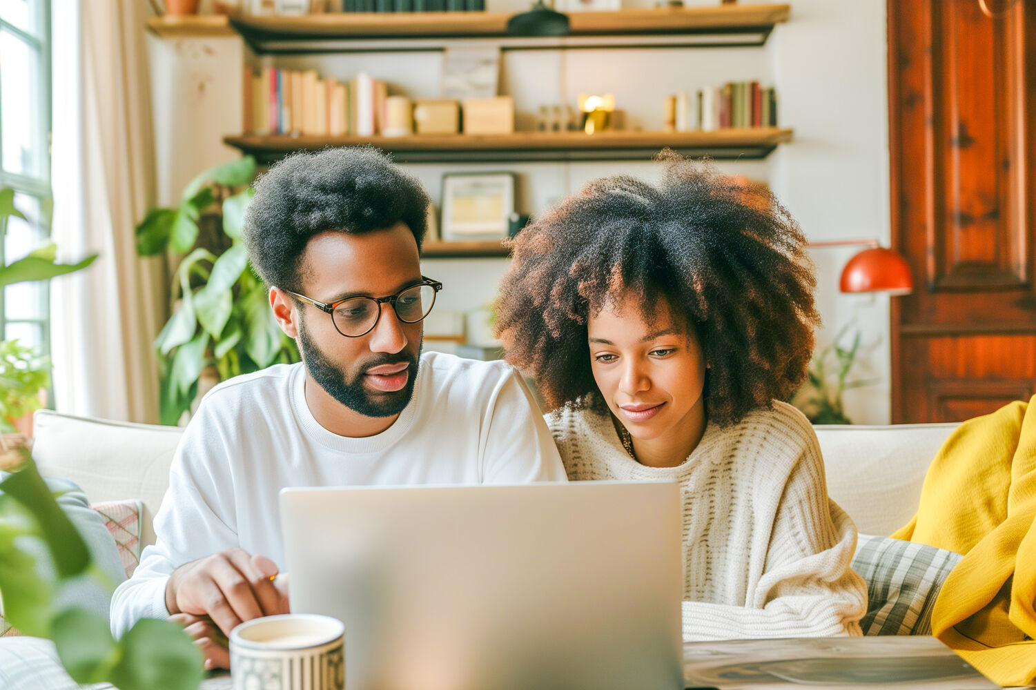 Een man en een vrouw kijken op de computer naar inboedelverzekeringen