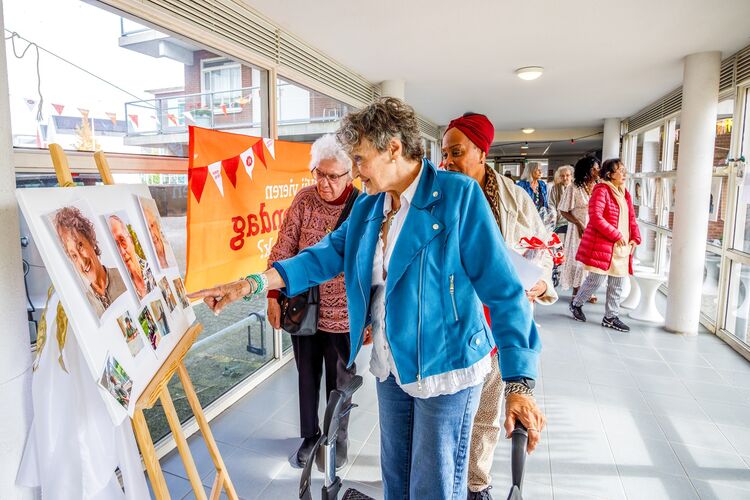 Bewoners van De Wasknijper lopen langs de portrette